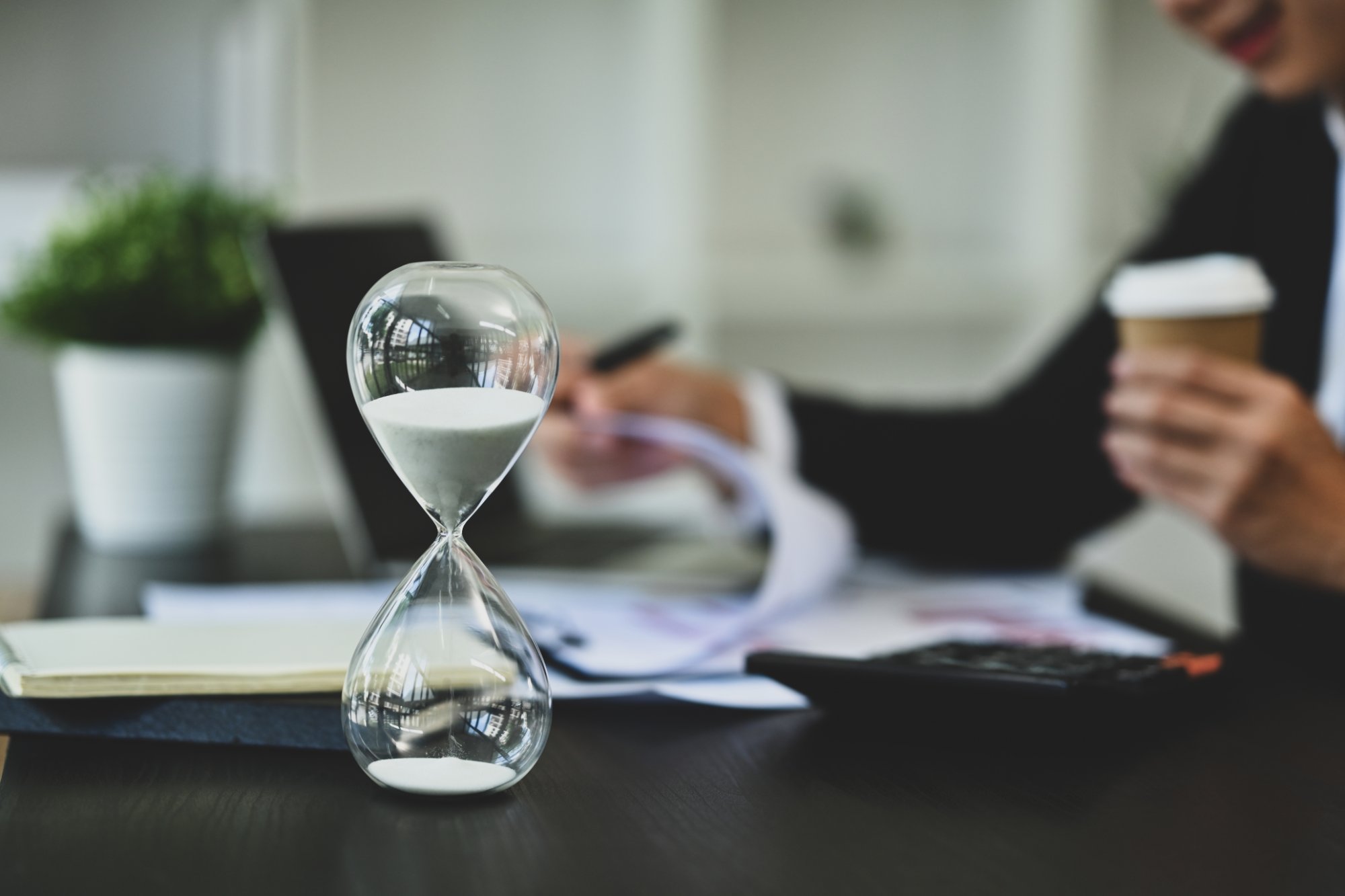 Hourglass on a desk beside paperwork, representing medical records retention periods